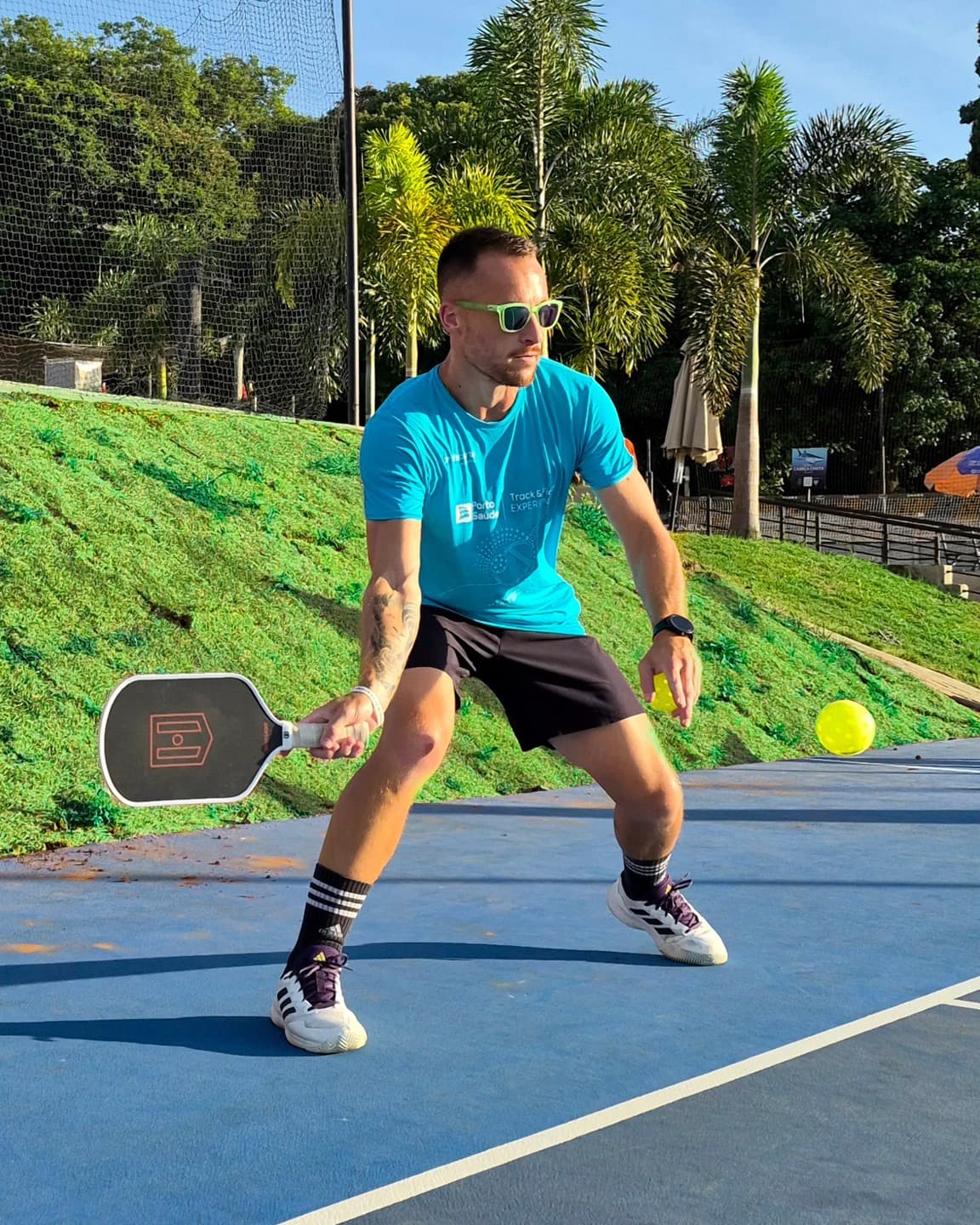 Professor da Sharx no pickleball, de raquete na mão, esperando a bola